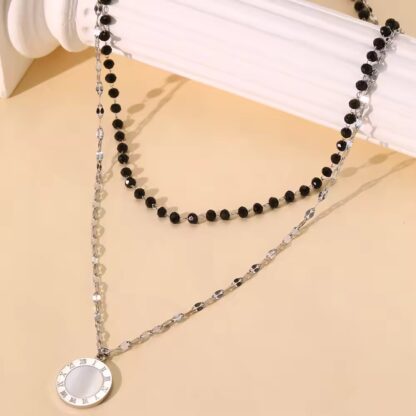 collier perles fines noires avec medaille